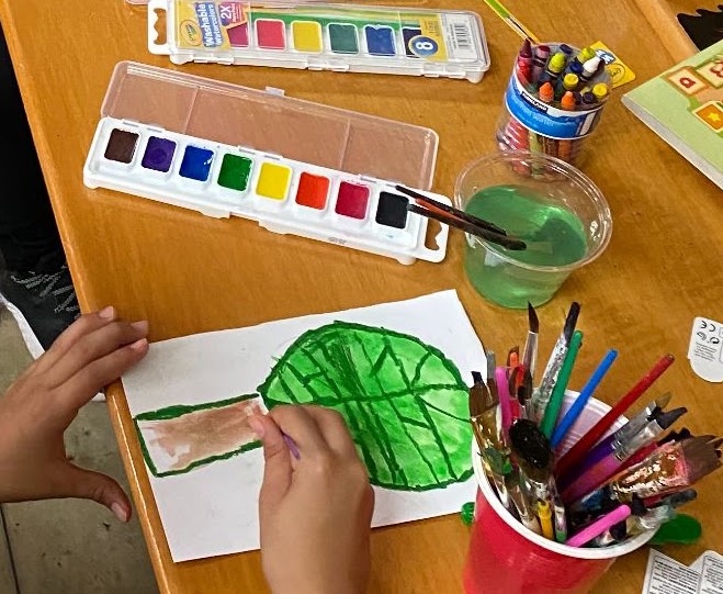 A student painting a watercolor leaf in a Meridian project